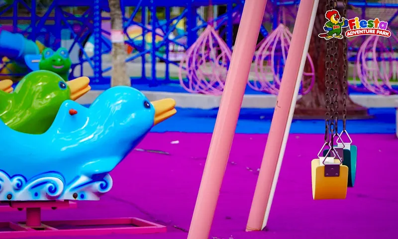 Blue dolphin-shaped kiddie rides on a purple surface