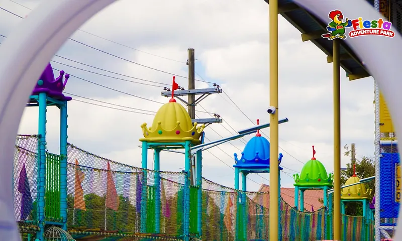 A kiddie ride with a colourful dome roof and hanging seats