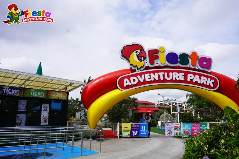The yellow entrance arch with the Fiesta Adventure Park sign against a blue sky