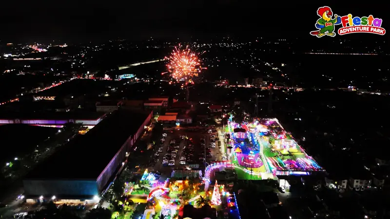Fireworks above the glowing park with the city lights of Lipa beyond