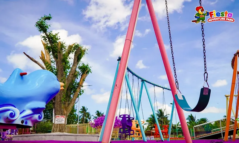 A pink-poled giant swing against a blue sky