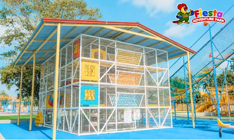 A glass-walled climbing tower with colourful nets inside