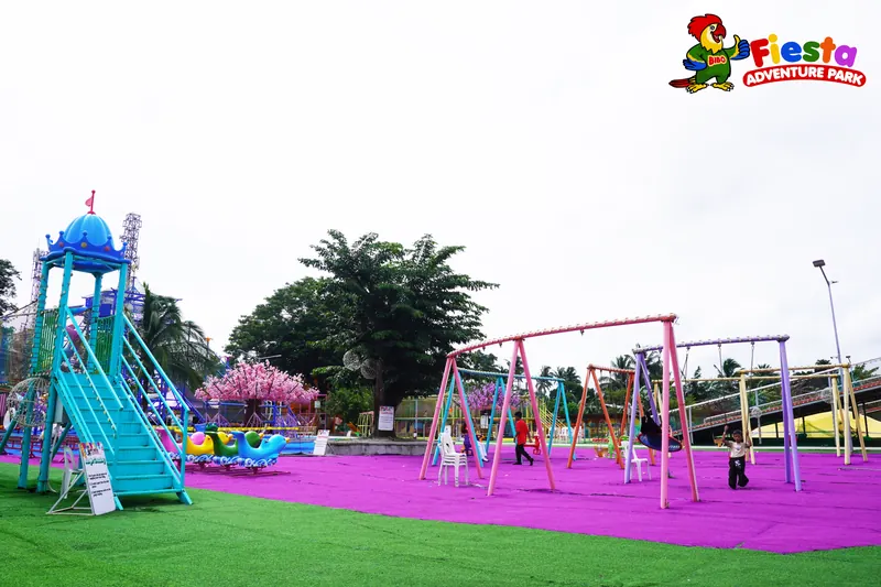 Tall swings and a pink swing frame on a wide green lawn