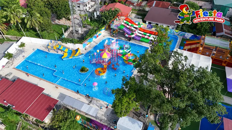 Angled drone view of the pools, slides and surrounding palms